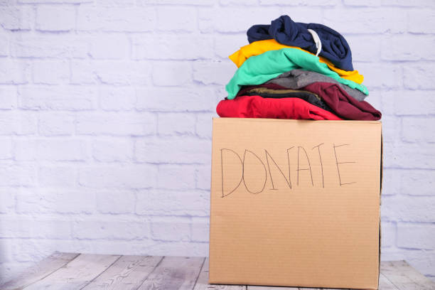 istock Donation box with donation clothes on a wooden table . 1278888499