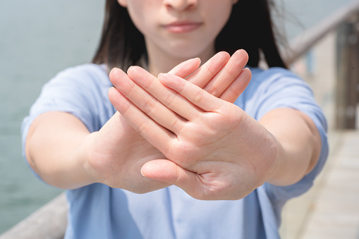 Women making stop gesture with two crossed palms