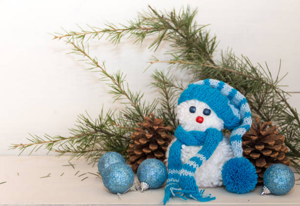 snowmen made with wool pompoms, on a Christmas background