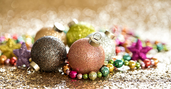 Christmas pastel colored ornaments on a gold glitter background. Very Shallow Depth.