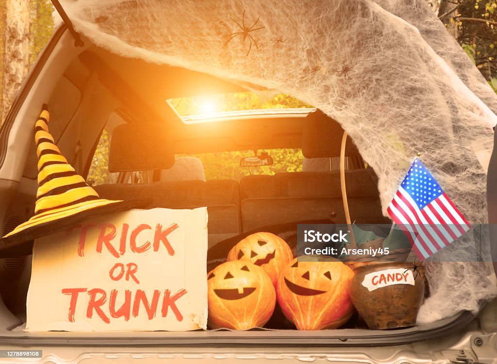 Trick or trunk. Concept celebrating Halloween in trunk of car. New trend celebrating traditional October holiday outdoor. Social distance and safe alternative celebration during coronavirus covid-19 Trunk or Treat Stock Photo