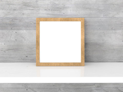 Interior layout of a poster with a square wooden frame on a white shelf against a wooden wall