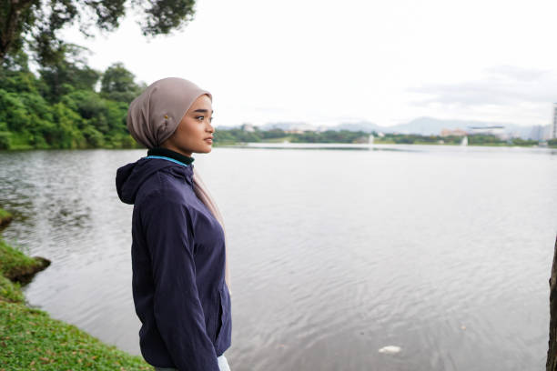 teenage hijab girl disfrutando solo en la naturaleza - lake asia young women beautiful people fotografías e imágenes de stock