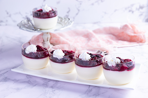 Panna cotta with strawberries, raspberries and blackberries on marble background
