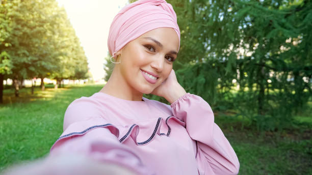 istock Young muslim woman in headscarf makes selfie using camera 1278908525
