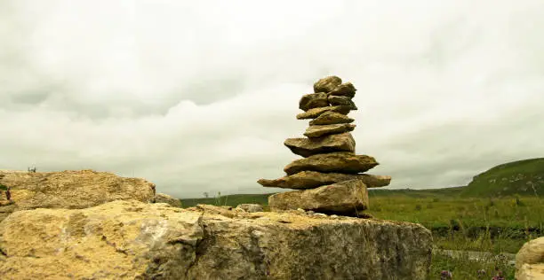 The Balanced stones on the alpine field near caucasus mountains against stormy sky