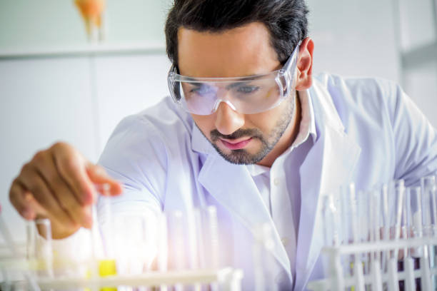 istock Attractive happiness scientist man lab technician assistant analyzing sample in test tube with microscope at laboratory. Medical, pharmaceutical and scientific research and development concept. 1278909793