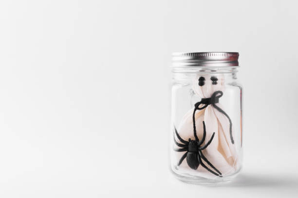 istock The white ghost scary face and black spider in jar glass 1278915416