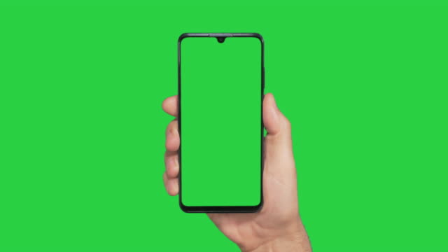 Hand holding mobile phone with green screen
