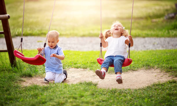 Boy and boy playing on the backyard Boy and boy playing on the backyard on swings. swinging stock pictures, royalty-free photos & images