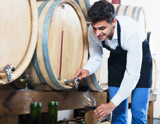 istock Seller pouring wine in cellar 1278917524