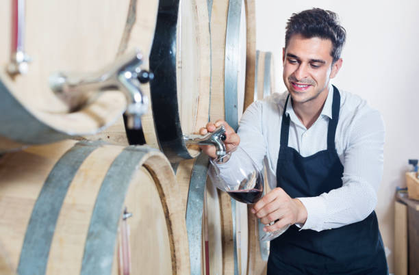 istock Man pouring red wine into glass in alcohol section 1278917534