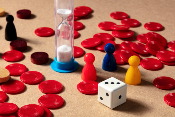 Playing board games at home, various pieces with a timer and a die cube