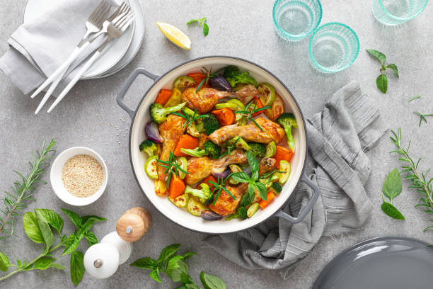istock Chicken drumsticks roasted with vegetables in cast iron pan on kitchen table, top down view 1278919214