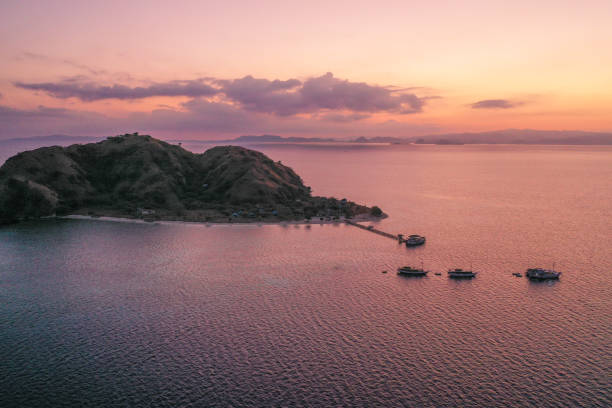istock Aerial view sunset over Kanawa island. It is a small beautiful tropical island, fully surrounded by white sandy beaches and coral reefs. It is located at the border of Komodo National Park, East Nusa Tenggara, Indonesia. 1278923708