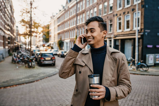 istock Asian businessman using smart phone and drinking coffee from reusable cup 1278926432