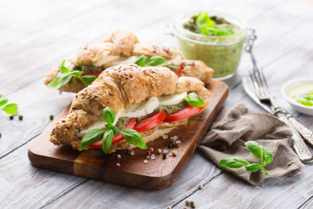 ð i croissant integrali runchy con mozzarella, pomodoro e pesto - morning tomato lettuce vegetable foto e immagini stock