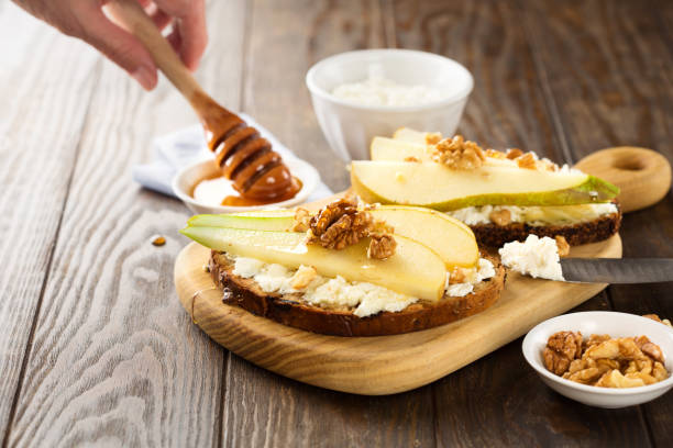 istock Appetizer bread bruschetta with pear, honey, hazelnuts and cottage cheese on old rustic wooden background 1278926984