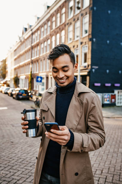 istock Asian businessman using smart phone and drinking coffee from reusable cup 1278927003