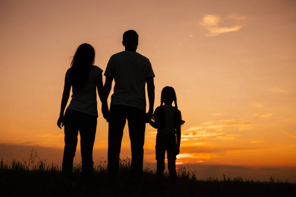 istock Unrecognizable family enjoying sunset in field 1278927871