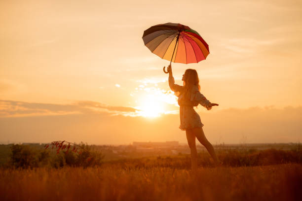 istock Young woman with umbrella dancing during sunset 1278927888