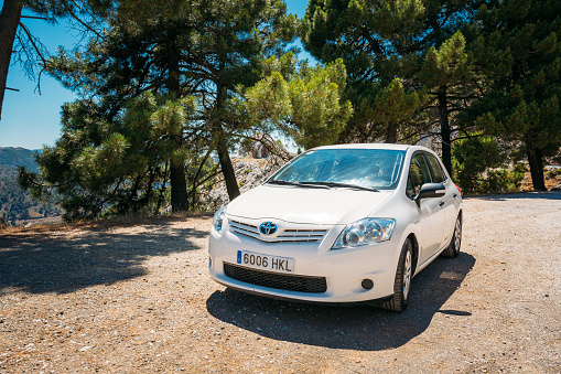 MIJAS, SPAIN - JUNE 19, 2015: White color Toyota Auris car on Spain nature landscape. The Toyota Auris is a compact hatchback derived from the Toyota Corolla