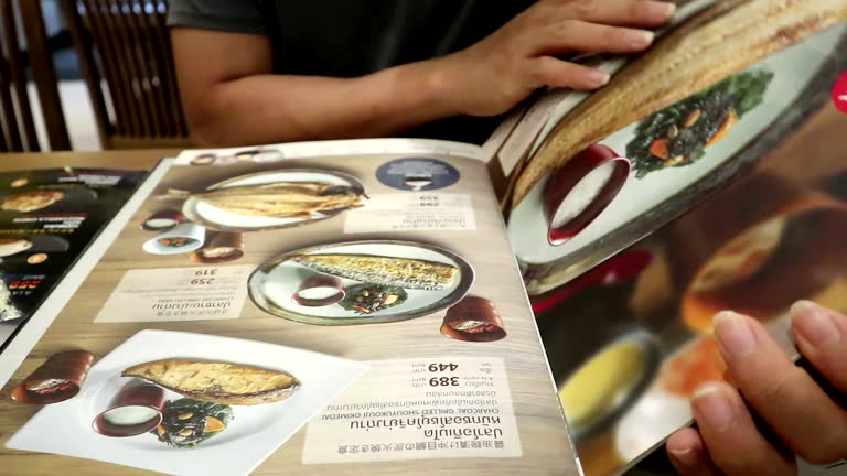 Men choosing dish menu in Japanese restaurant at True Digital Park Sukhumvit road Bangkok Thailand