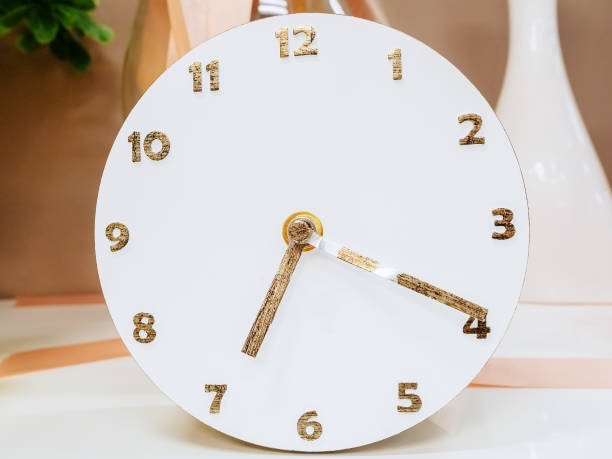 istock Decorative round white table clock with golden numbers and arrows 1278941534