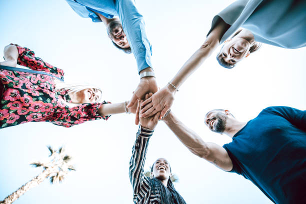 istock Group of young adults join their hands together 1278941584