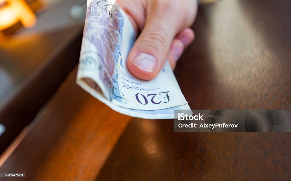 Man paying by 20 pound notes at cafe or shop in London Paper Currency Stock Photo