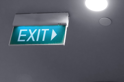 green emergency exit way light box sign on ceiling