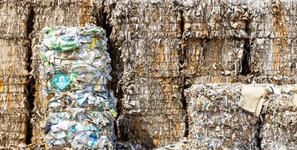 Wastepaper for Recycling, background of paper textures piled ready to recycle, Stack of paper waste before shredding at recycling plant.