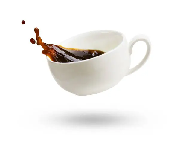 A cup of black coffee with splash isolated on a white background