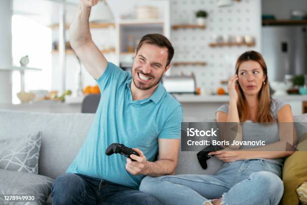 Boyfriend and girlfriend playing video games with controller on console  Stock Photo by ©DragosCondreaW 564191710