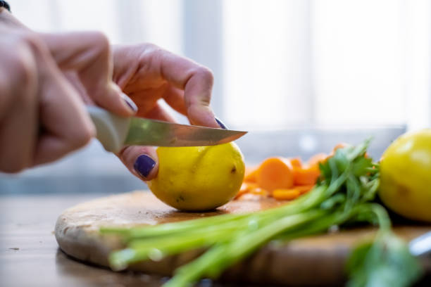 istock Woman cutting lemon on cutting board 1278951899