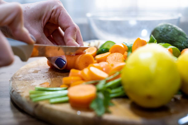 istock Woman chopping carrot on cutting board 1278953390