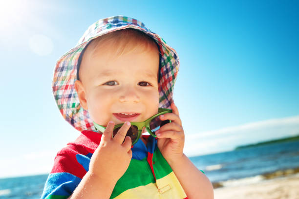 istock Little boy is smiling at the beach in hat with sunglasses 1278955563