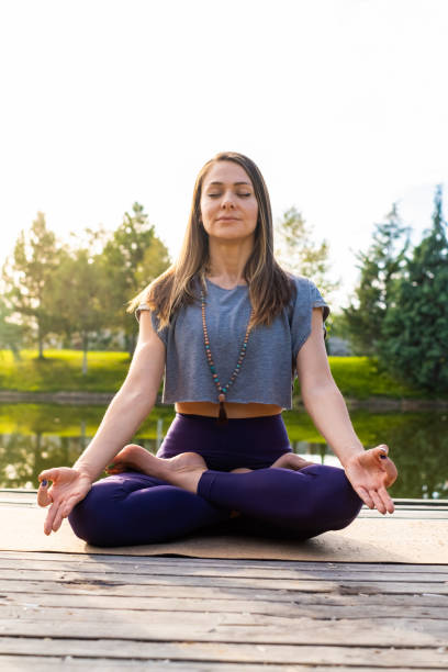 istock Young woman doing yoga exercise in nature park 1278957457