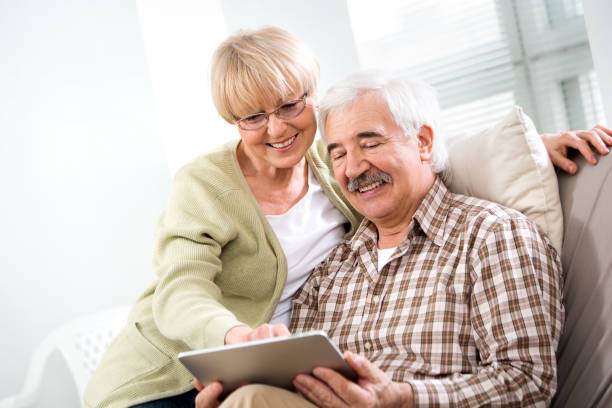istock Elderly couple have fun at home with a tablet computer 1278961140