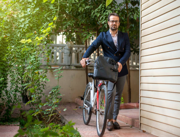 Alternative commute concept. Young man going to work with his bike. Alternative commute concept. Young man going to work with his bike. Young man not using public transport goes to work by bicycle leather medical bag stock pictures, royalty-free photos & images