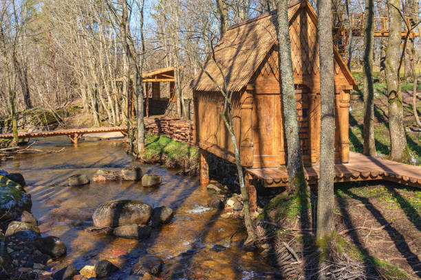 istock Idyllic log cabins at a stream in the woodlands in spring 1278964214