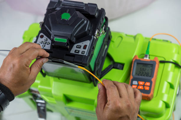 istock Optical fiber installation with Digital Fiber Optical Fusion Splicing machine. High precision fiber optic cleaver is being used during a fiber optic wire install at House.  Welding of optical fibers. 1278965650