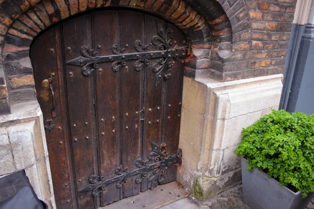 doors closing the entrance from the street to the basement of a medieval brick house - lock door horror gate imagens e fotografias de stock