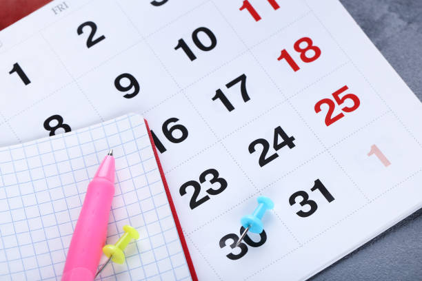 istock Calendar page with notepad and pen on gray background 1278970375