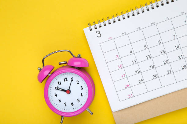 istock Calendar page with alarm clock on yellow background 1278970545