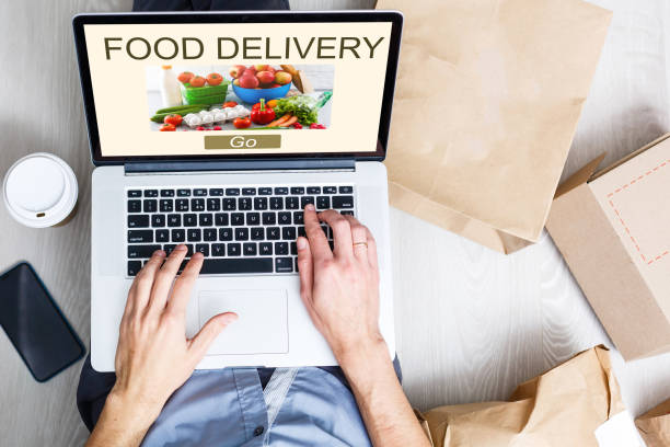 istock Man ordering take away food by internet with a laptop while lying at home. 1278971805