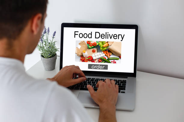 istock Man ordering take away food by internet with a laptop while lying at home. 1278971904