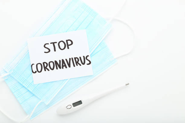 istock Text Stop Coronavirus with medicine masks and thermometer on white background 1278972171