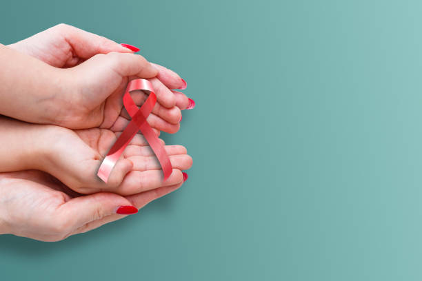 istock red aids ribbon in hand. 1278973931