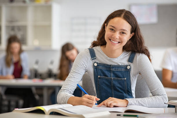 Happy school girl looking at camera in class